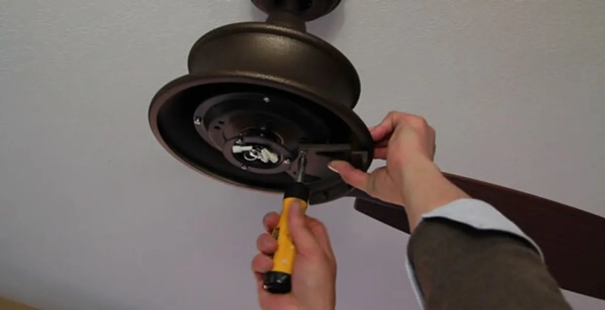 Electrician installing ceiling fan mounting bracket and fixture in Columbia, MO