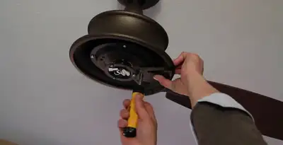 Electrician installing ceiling fan mounting bracket and fixture in Columbia, MO