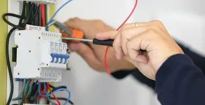Electrician installing and adjusting circuit breakers in an electrical panel in Columbia, MO