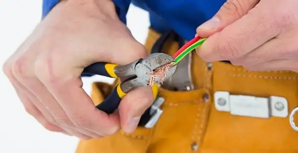 licensed electrician securing electrical wiring with professional tools during service work in Columbia, MO