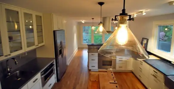 Residential electrician installing modern indoor light fixture in a home in Columbia, MO