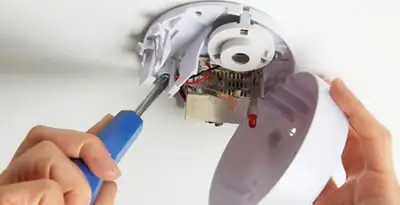 Certified technician wiring smoke detector during installation in Columbia, MO